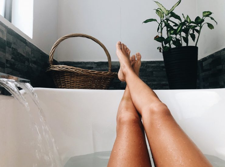 Woman relaxing in bath with feet on the tub edge