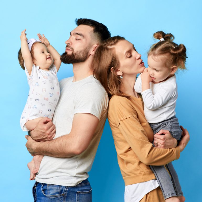 A couple holding kids