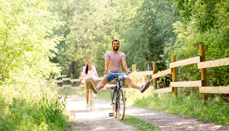 Couple in a happy healthy relationship with bicycles at summer park
