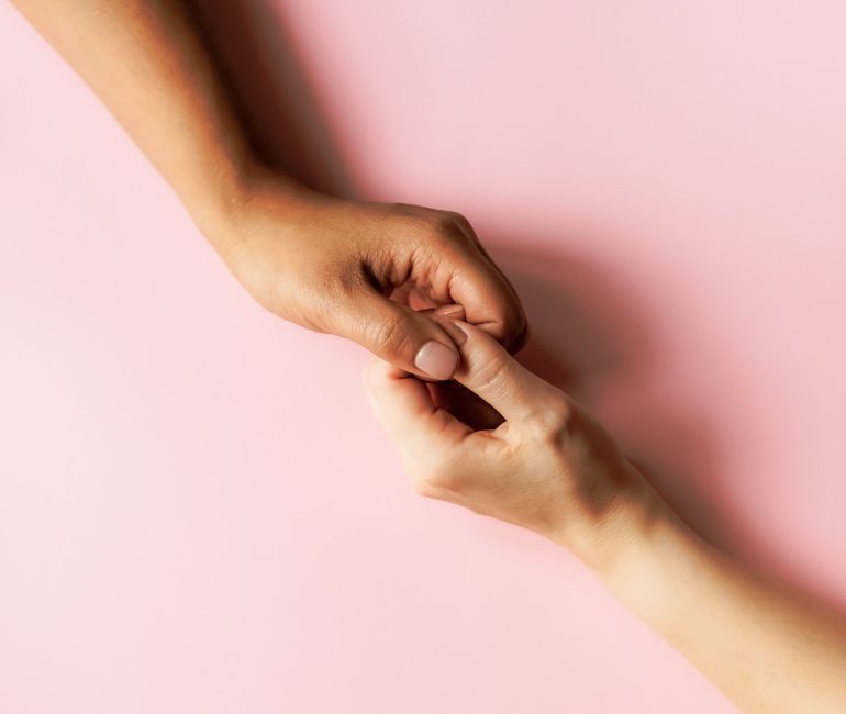 Two people reaching out and holding hands